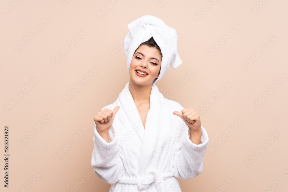 Teenager girl in a bathrobe over isolated background proud and self-satisfied Teenager girl in a bathrobe over isolated background proud and self-satisfied
