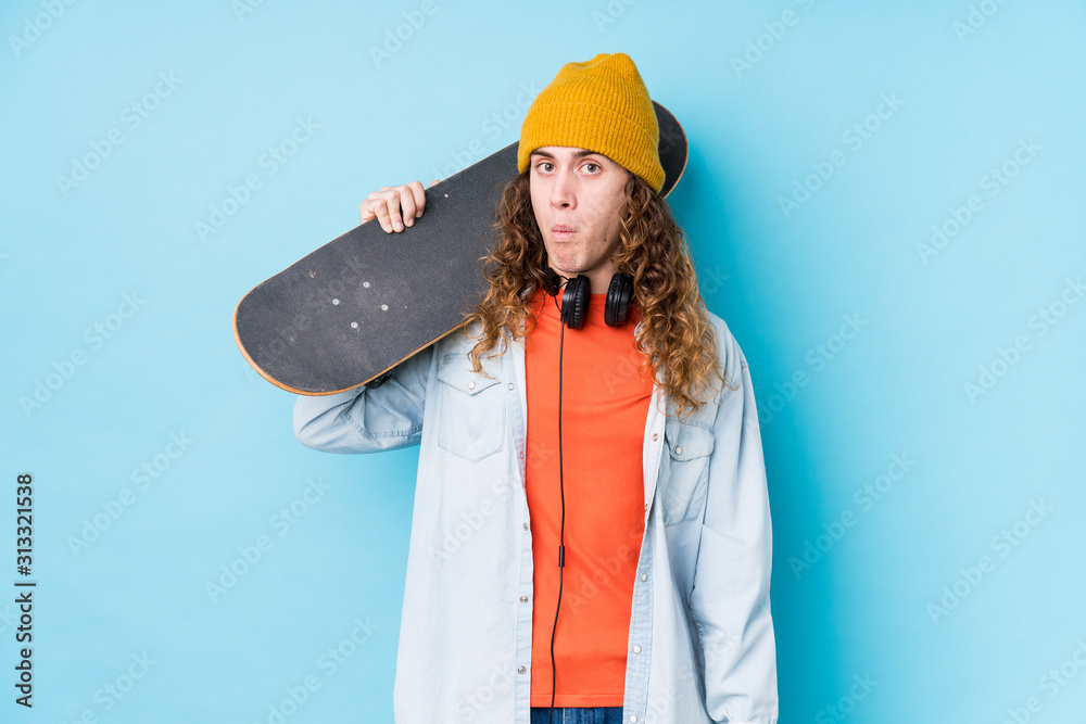 Young caucasian skater man isolated shrugs shoulders and open eyes confused. Young caucasian skater man isolated shrugs shoulders and open eyes confused.