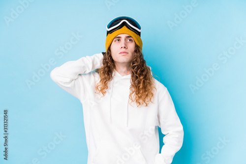 Young caucasian man wearing a ski clothes isolated touching back of head, thinking and making a choice.