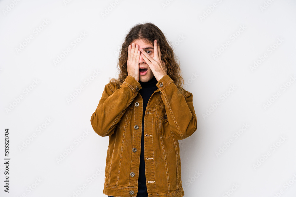 Long hair man posing isolated blink through fingers frightened and nervous. Long hair man posing isolated blink through fingers frightened and nervous.