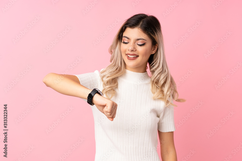 Teenager girl over isolated pink background with wrist watch Teenager girl over isolated pink background with wrist watch