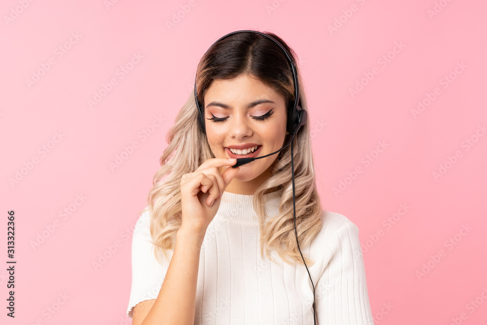 Teenager girl over isolated pink background working with headset Teenager girl over isolated pink background working with headset