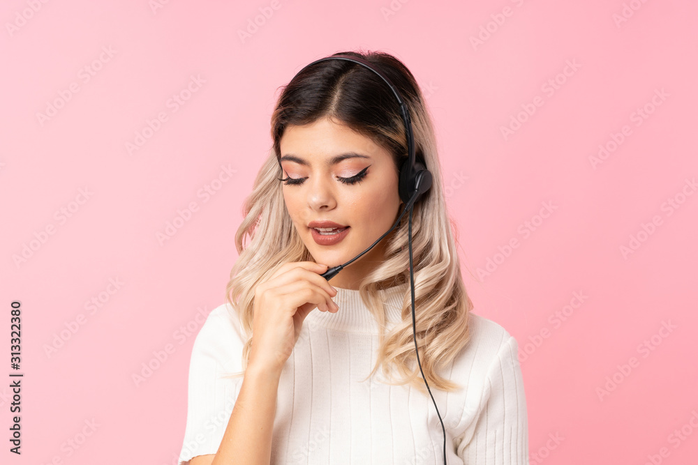 Teenager girl over isolated pink background working with headset