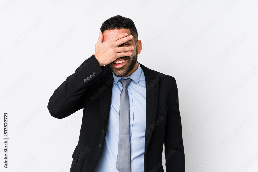 Young latin business woman against a white background isolated blink at the camera through fingers, embarrassed covering face. Young latin business woman against a white background isolated blink at the camera through fingers, embarrassed covering face.