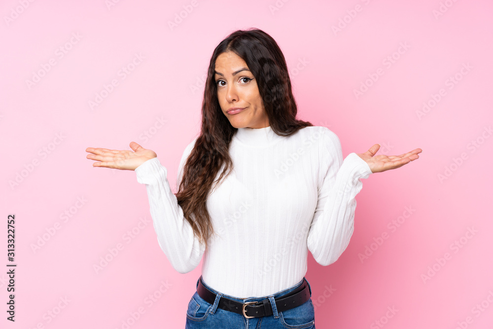 Young woman over isolated pink background having doubts while raising hands Young woman over isolated pink background having doubts while raising hands