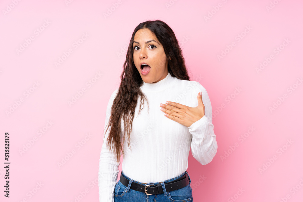 Young woman over isolated pink background surprised and shocked while looking right Young woman over isolated pink background surprised and shocked while looking right