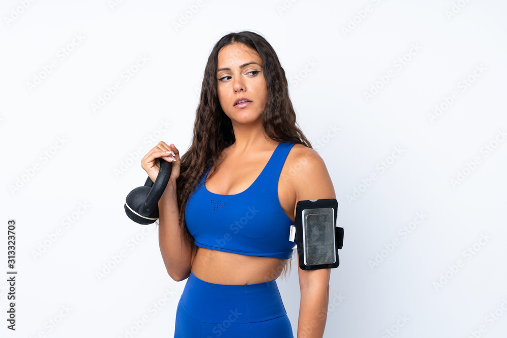 Young sport woman over isolated white background making weightlifting with kettlebell Young sport woman over isolated white background making weightlifting with kettlebell