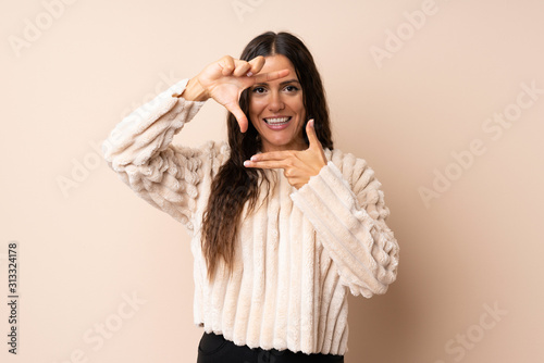 Young woman over isolated background focusing face. Framing symbol