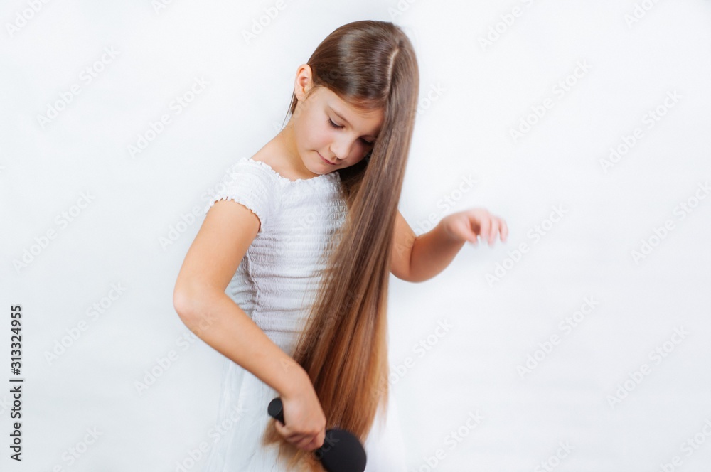 Cute smiling little girl combing her hair comb makes hair Cute smiling little girl combing her hair comb makes hair