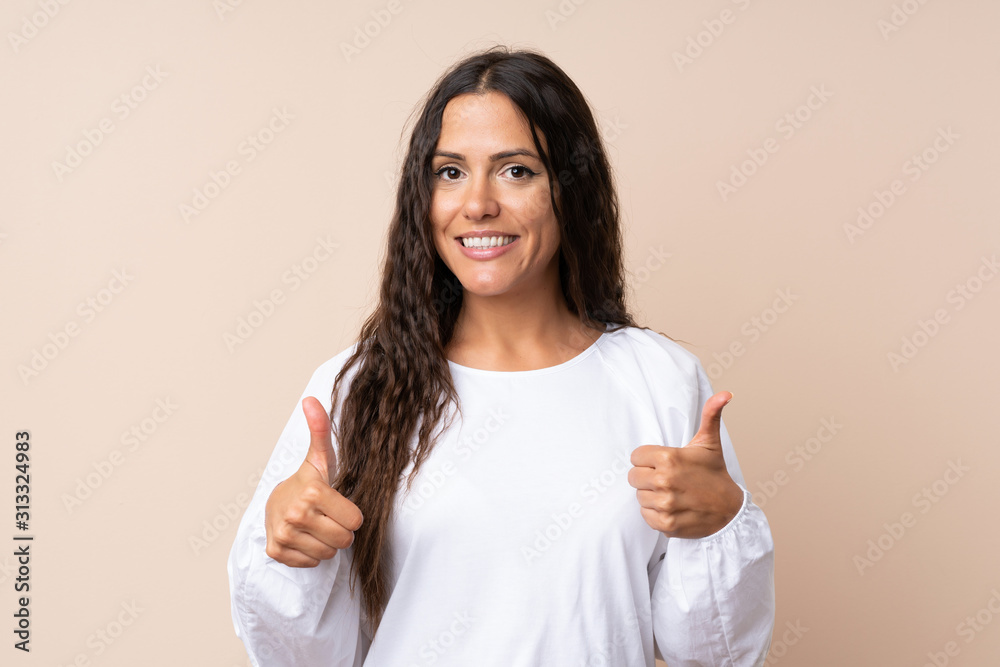 Young woman over isolated background giving a thumbs up gesture Young woman over isolated background giving a thumbs up gesture