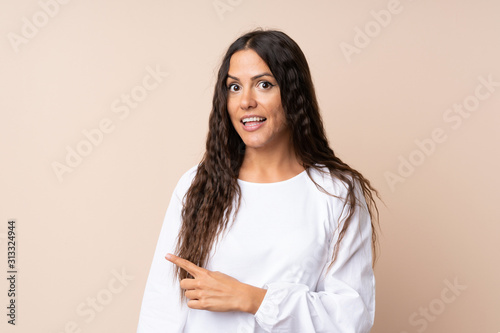 Young woman over isolated background pointing finger to the side