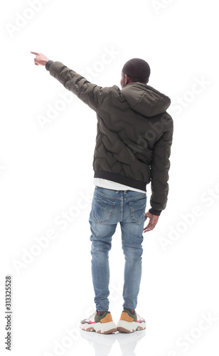 casual guy in black jacket looking at white wall