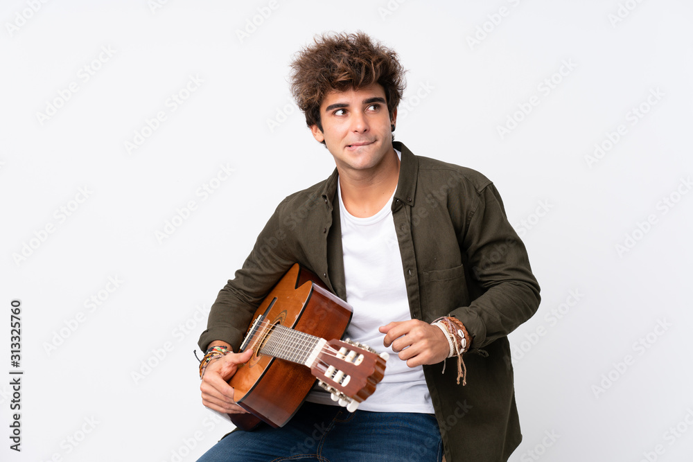 Young caucasian man with guitar over isolated white background having doubts and with confuse face expression Young caucasian man with guitar over isolated white background having doubts and with confuse face expression