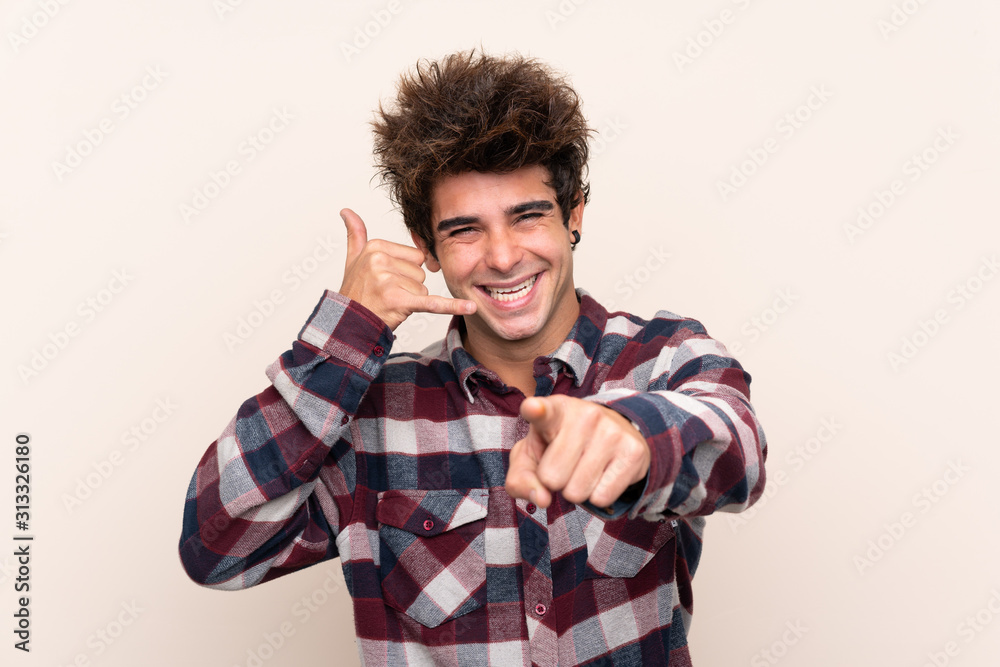 Young caucasian man making phone gesture and pointing front Young caucasian man making phone gesture and pointing front