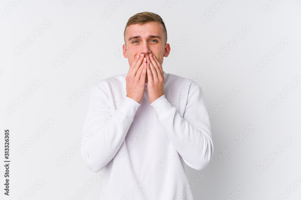 Young caucasian man on white background laughing about something, covering mouth with hands. Young caucasian man on white background laughing about something, covering mouth with hands.