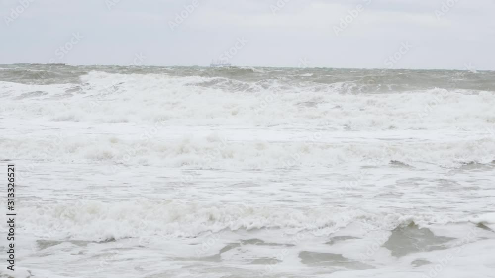 Waves of Mediterranean Sea rolling to the sandy beach. Close-up shot of sea foam Waves of Mediterranean Sea rolling to the sandy beach. Close-up shot of sea foam