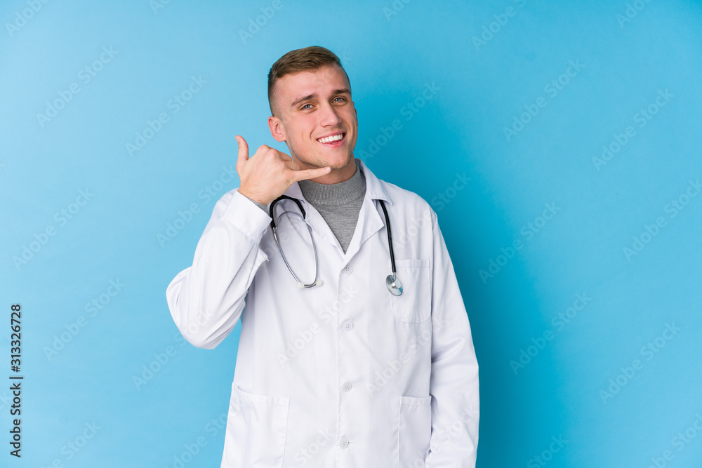 Young caucasian doctor man showing a mobile phone call gesture with fingers. Young caucasian doctor man showing a mobile phone call gesture with fingers.