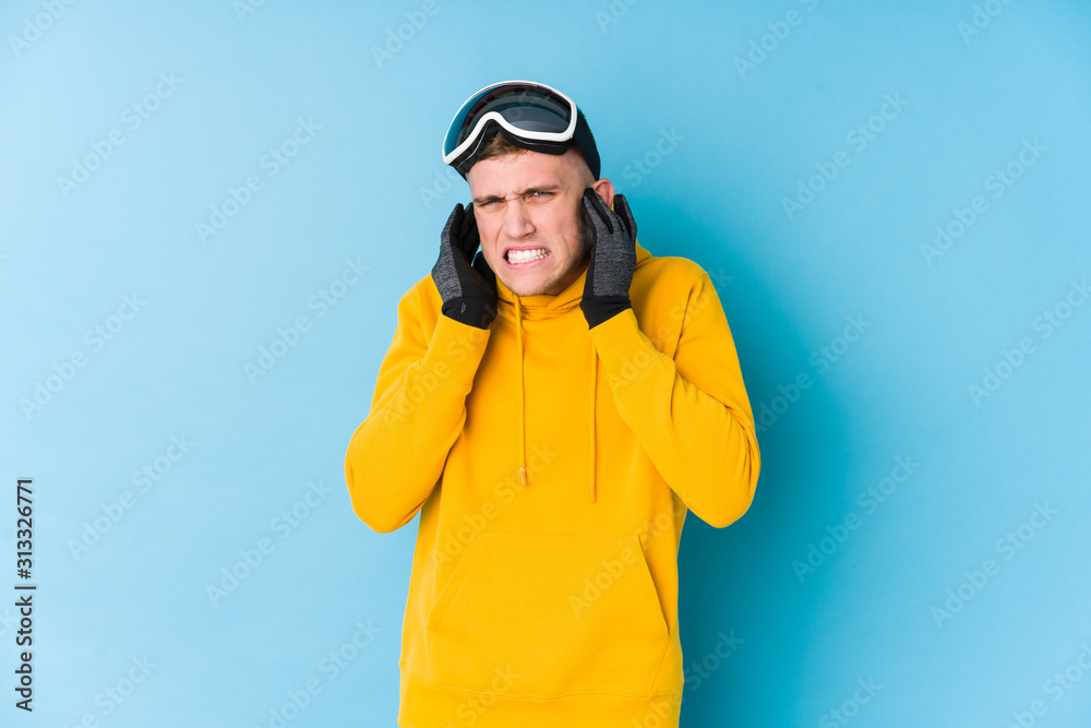 Young skier man covering ears with hands. Young skier man covering ears with hands.