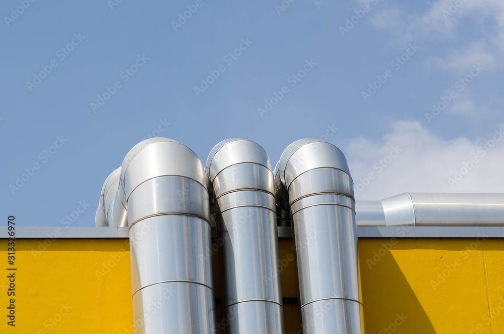 heating system or utility lines on a building. The pipes of the service system on the roof are covered with a galvanized steel cover. heating system or utility lines on a building. The pipes of the service system on the roof are covered with a galvanized steel cover.