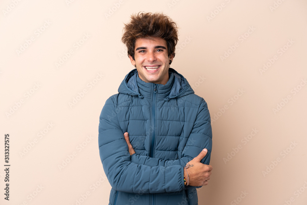 Man wearing winter jacket over isolated background smiling a lot Man wearing winter jacket over isolated background smiling a lot