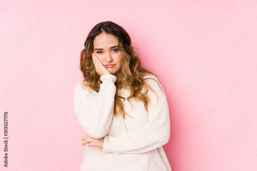 Young curvy woman posing in a pink background isolated who is bored, fatigued and need a relax day. Young curvy woman posing in a pink background isolated who is bored, fatigued and need a relax day.