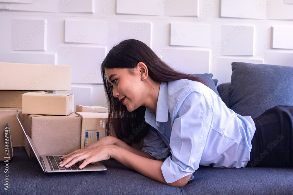 The young Asia Businesswoman.She use computer notebook.She makes it for order online.She is happy and smiles.Gift,Business,Photo concept work and Shopping. The young Asia Businesswoman.She use computer notebook.She makes it for order online.She is happy and smiles.Gift,Business,Photo concept work and Shopping.