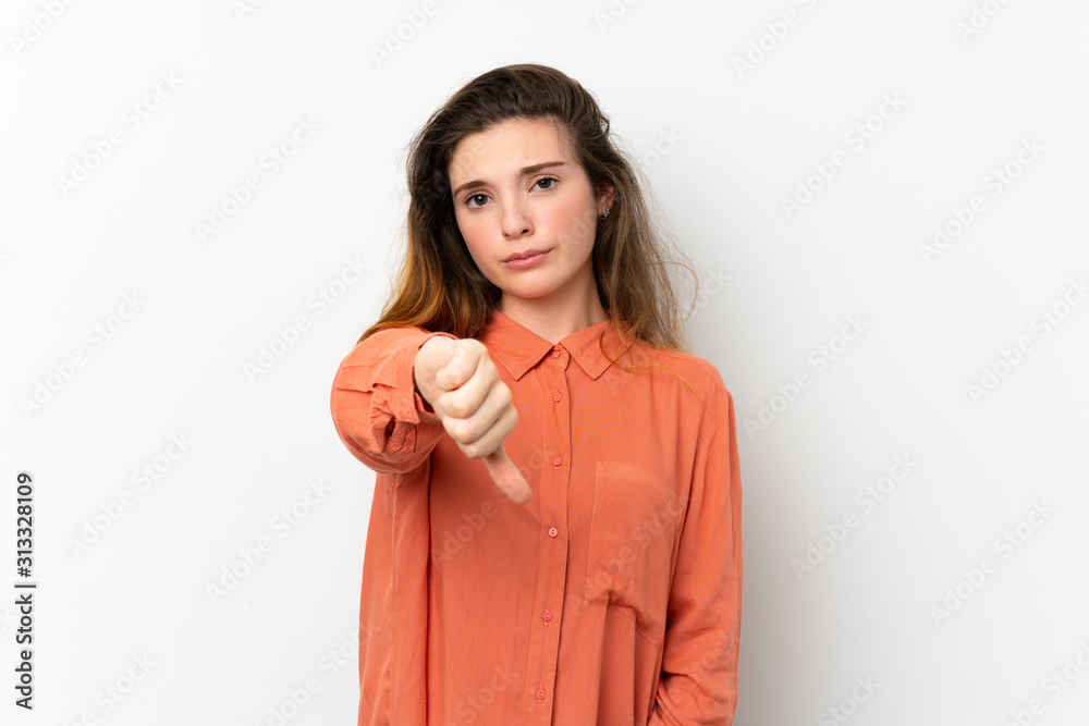 Young brunette girl over isolated white background showing thumb down with negative expression Young brunette girl over isolated white background showing thumb down with negative expression