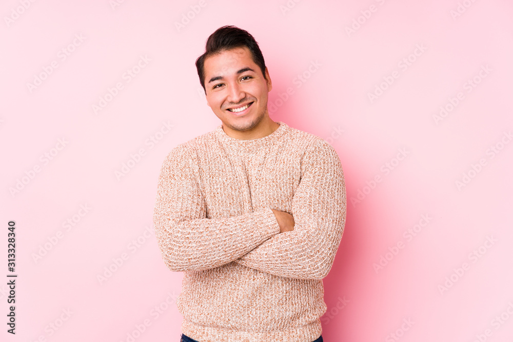 Young curvy man posing in a pink background isolated laughing and having fun. Young curvy man posing in a pink background isolated laughing and having fun.