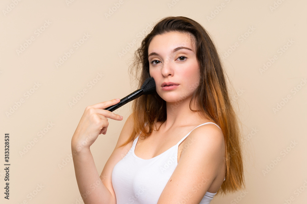 Young brunette girl with makeup brush over isolated background Young brunette girl with makeup brush over isolated background
