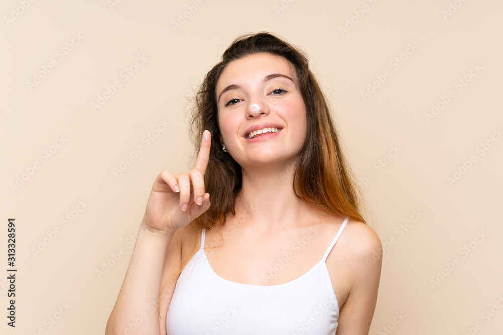 Young brunette girl with moisturizer over isolated background Young brunette girl with moisturizer over isolated background