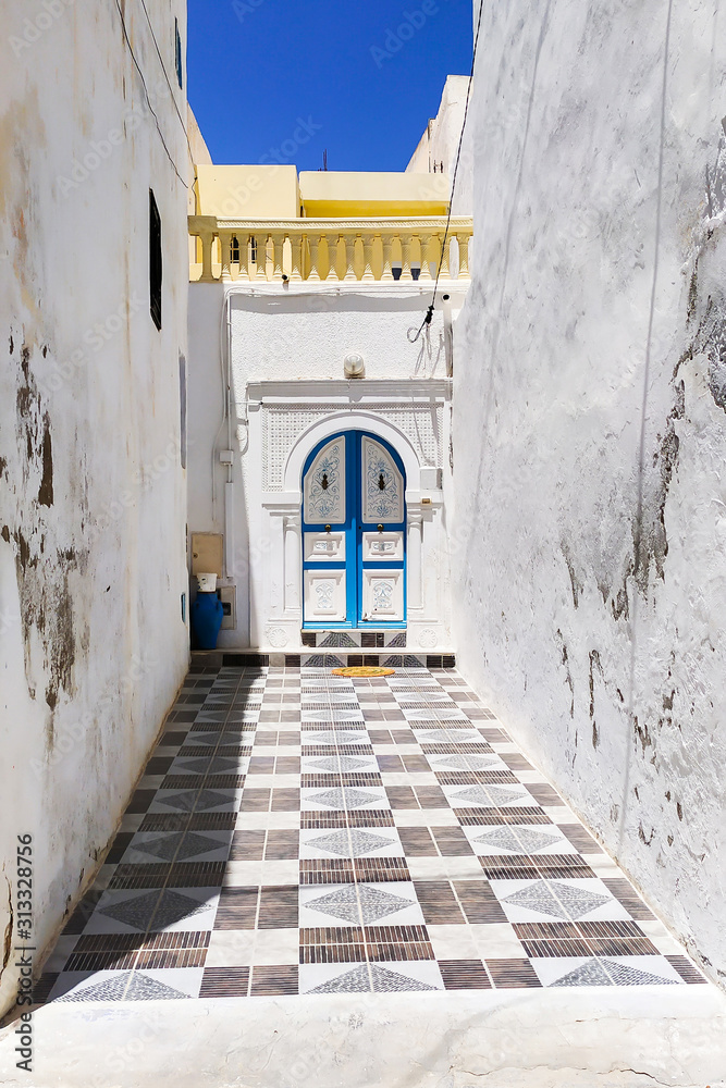 The narrow lane, decorated with the rug, made of ceramic tiles, Mahdia, Tunisia