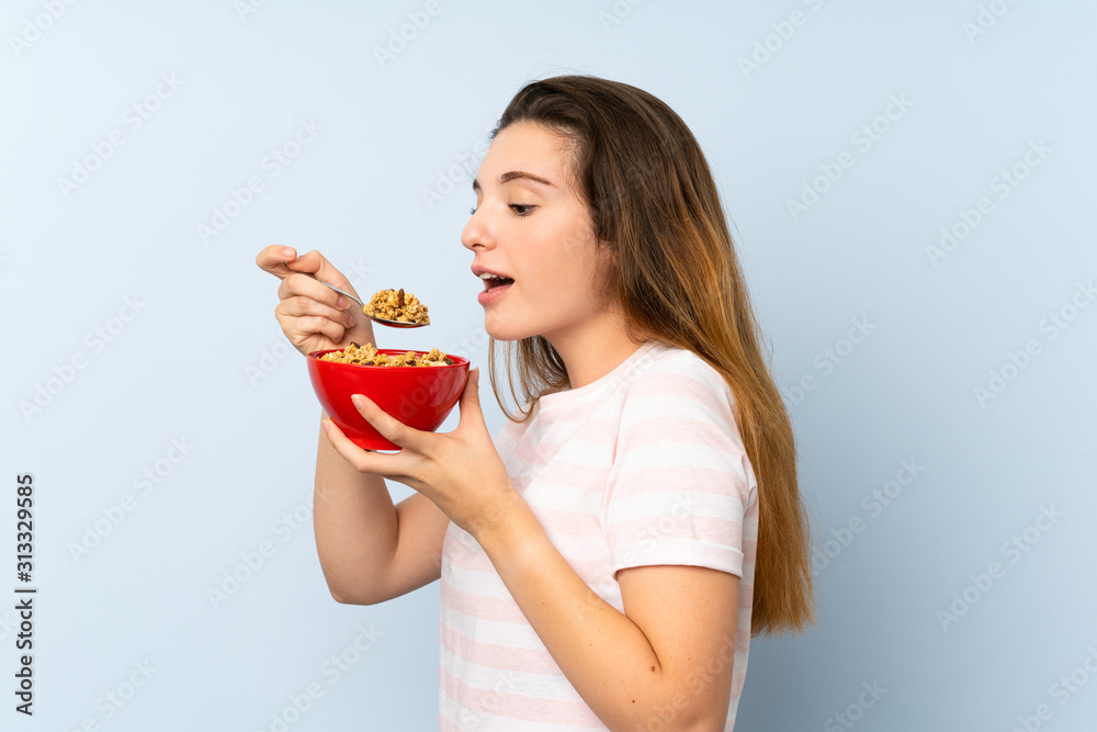 Young brunette girl holding a bowl of cereals over isolated background Young brunette girl holding a bowl of cereals over isolated background