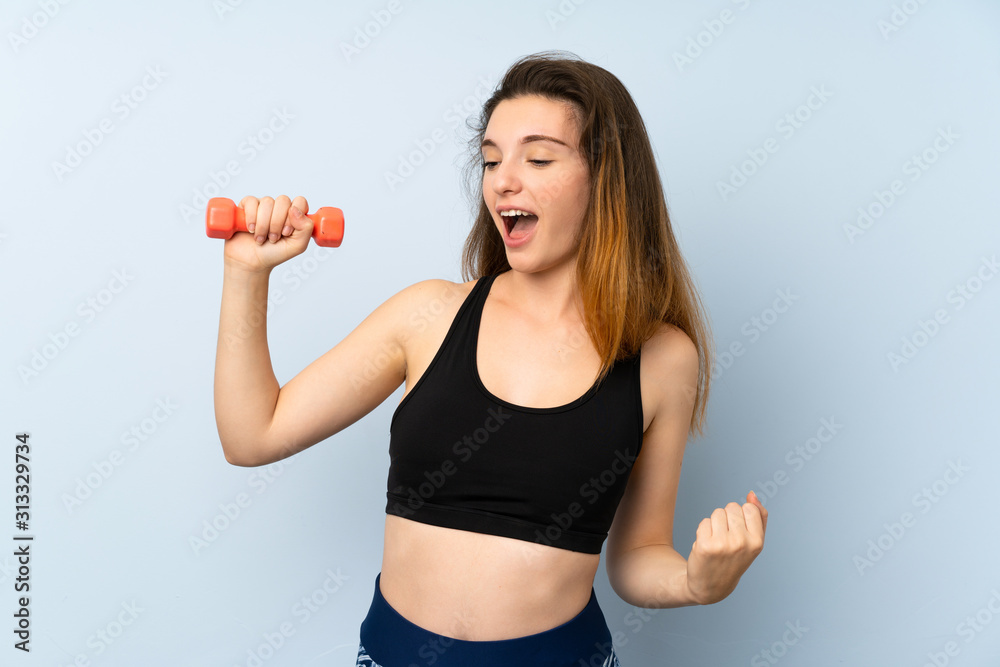 Young sport woman with weightlifting over isolated blue background celebrating a victory Young sport woman with weightlifting over isolated blue background celebrating a victory