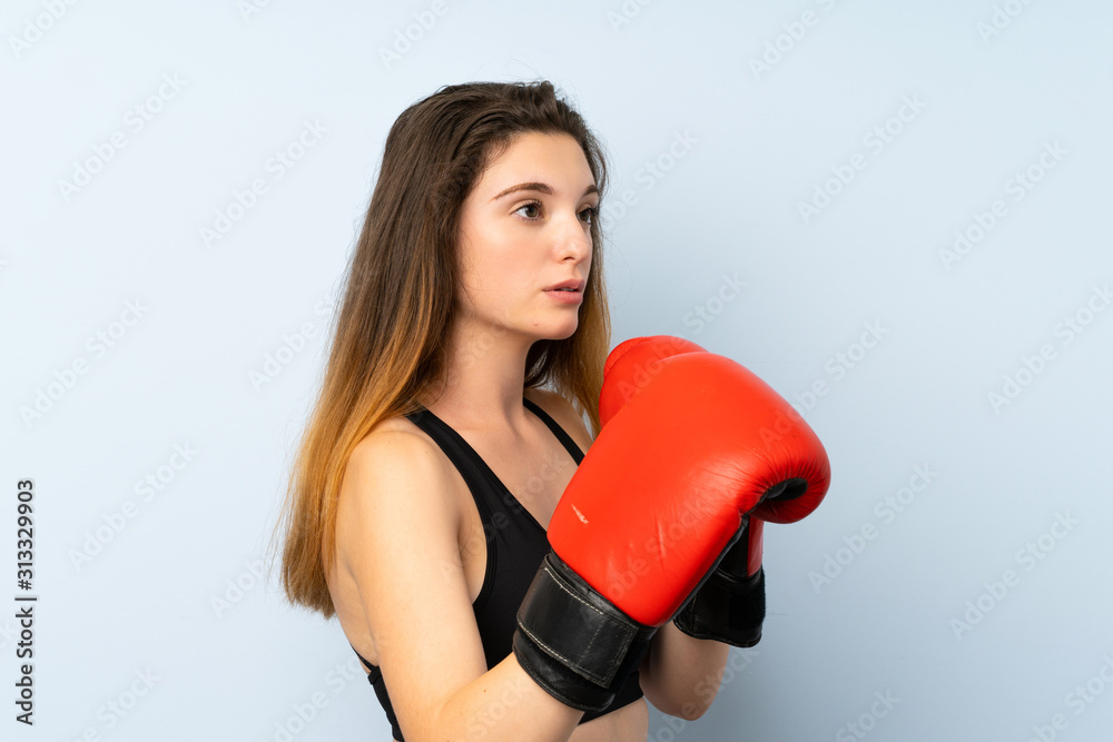 Young brunette girl with boxing gloves over isolated background Young brunette girl with boxing gloves over isolated background