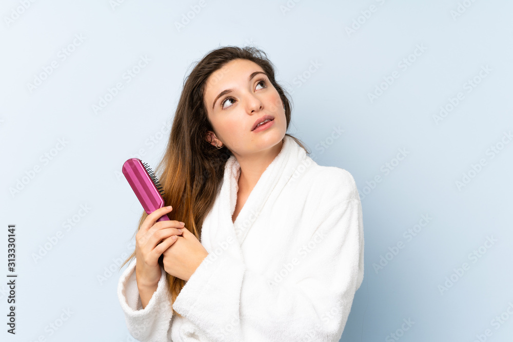Young woman in a bathrobe with with hair comb.