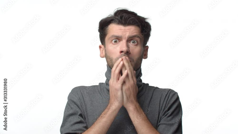 Emotions, people concept. Slow-motion bearded handsome man in turtleneck sweater, seeing something scary, look shocked, gasping close mouth with hands, stare startled, shake head upset Emotions, people concept. Slow-motion bearded handsome man in turtleneck sweater, seeing something scary, look shocked, gasping close mouth with hands, stare startled, shake head upset