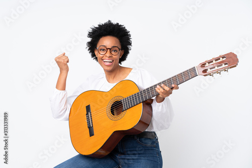 African american woman with guitar over isolated background celebrating a victory