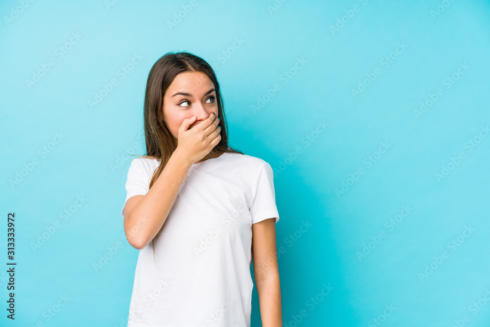 Young caucasian woman isolated thoughtful looking to a copy space covering mouth with hand. Young caucasian woman isolated thoughtful looking to a copy space covering mouth with hand.