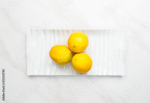 3 meyer lemons on a plate