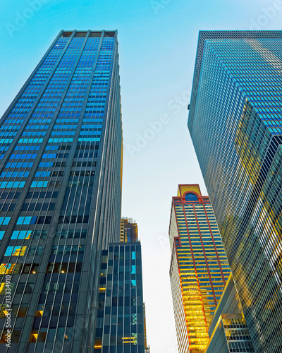 Bottom up Street view on Financial District of Lower Manhattan  New York City  NYC  USA. Skyscrapers tall glass buildings United States of America. Blue sky on background. Empty place for copy space.