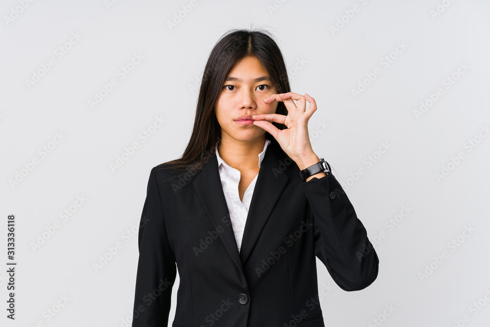 Young asian business woman with fingers on lips keeping a secret. Young asian business woman with fingers on lips keeping a secret.