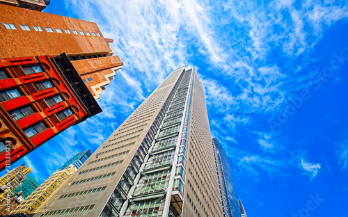 Bottom up Street view on Financial District of Lower Manhattan, New York City, NYC, USA. Skyscrapers tall glass buildings United States of America. Blue sky on background. Empty place for copy space.