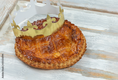 Epiphany Twelfth Night cake french galette des rois made of puff pastry, with the charm inside, open crown leaning on top photo