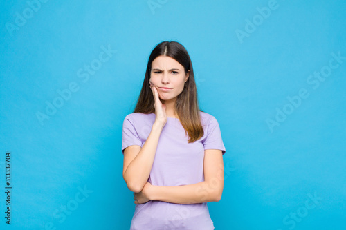 Obraz na plátně young pretty woman holding cheek and suffering painful toothache, feeling ill, m