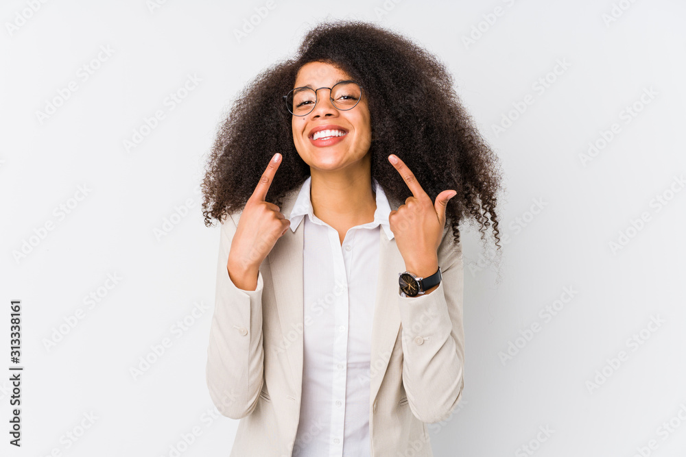 Young african american business woman smiles, pointing fingers at mouth. Young african american business woman smiles, pointing fingers at mouth.