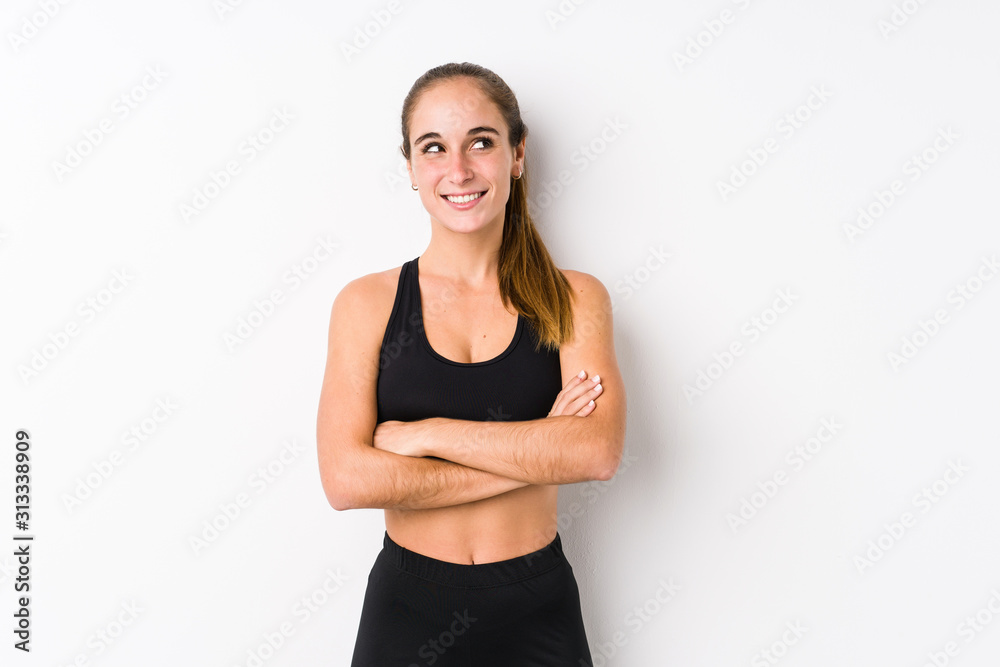 Young caucasian fitness woman posing in a white background smiling confident with crossed arms. Young caucasian fitness woman posing in a white background smiling confident with crossed arms.