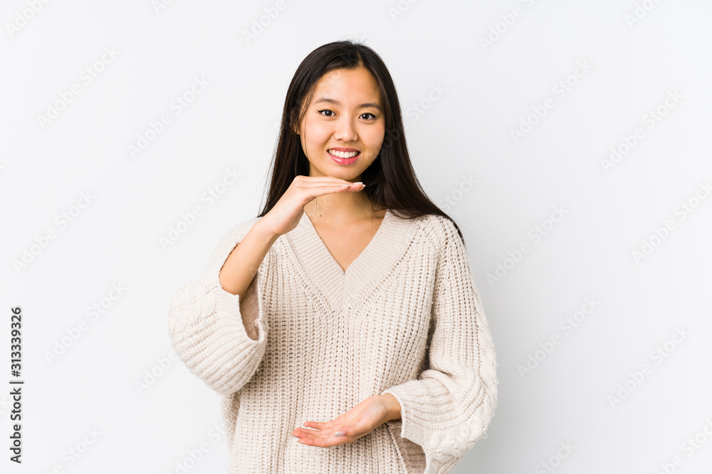 Young chinese woman isolated holding something with both hands, product presentation. Young chinese woman isolated holding something with both hands, product presentation.