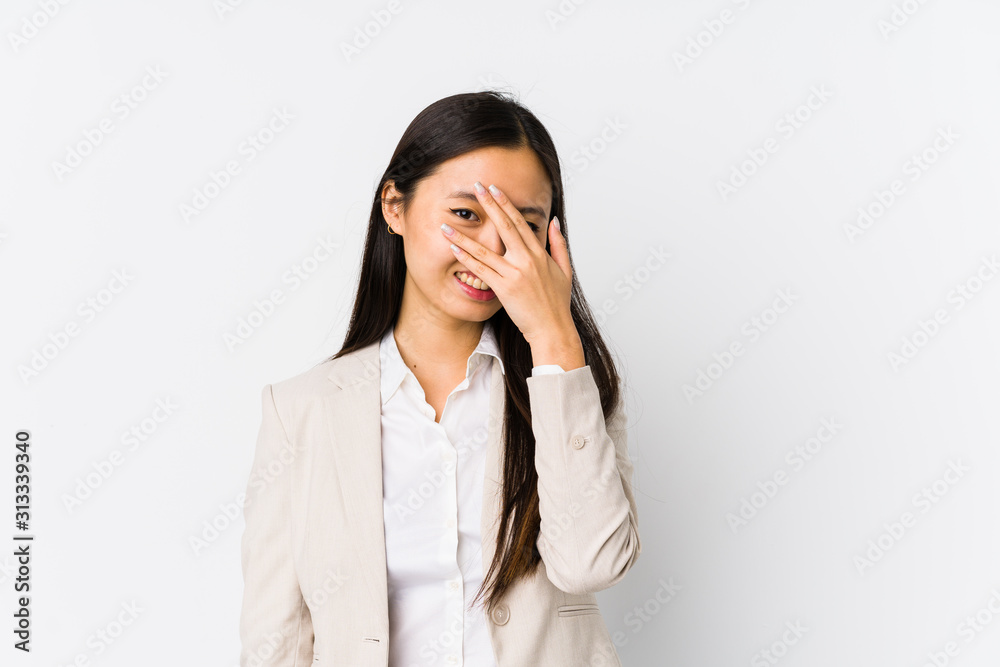Young chinese business woman isolated blink at the camera through fingers, embarrassed covering face. Young chinese business woman isolated blink at the camera through fingers, embarrassed covering face.