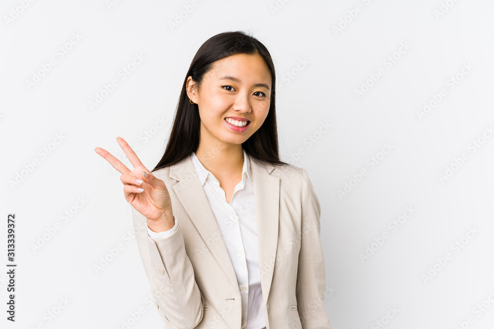 Young chinese business woman isolated joyful and carefree showing a peace symbol with fingers. Young chinese business woman isolated joyful and carefree showing a peace symbol with fingers.