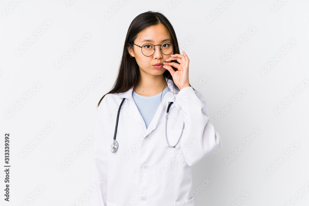 Young doctor chinese woman isolated with fingers on lips keeping a secret. Young doctor chinese woman isolated with fingers on lips keeping a secret.